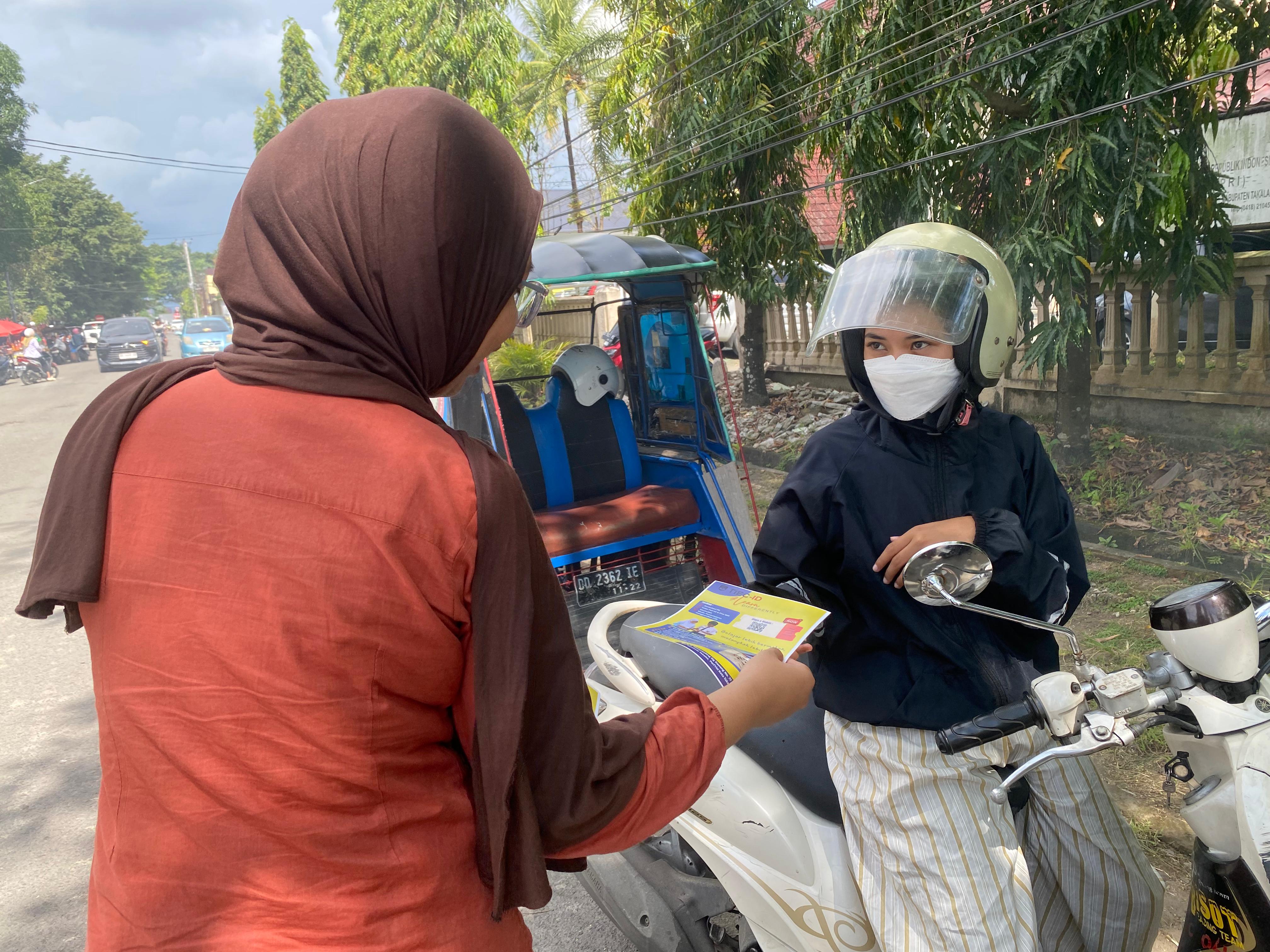 Membagikan brosur ke orang tua siswa pada saat pulang sekolah 